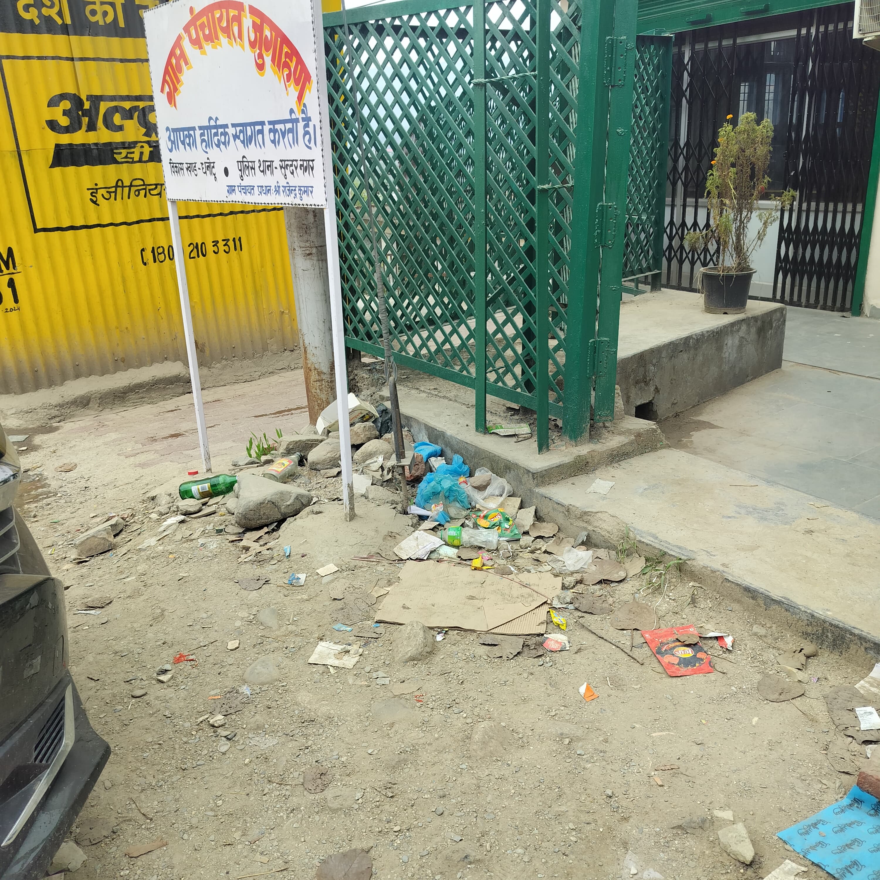 हिमाचल प्रदेश राज्य सहकारी बैंक धनोटू के गेट के साथ शराब की बोतलें और फैला कूड़ा -कर्कट